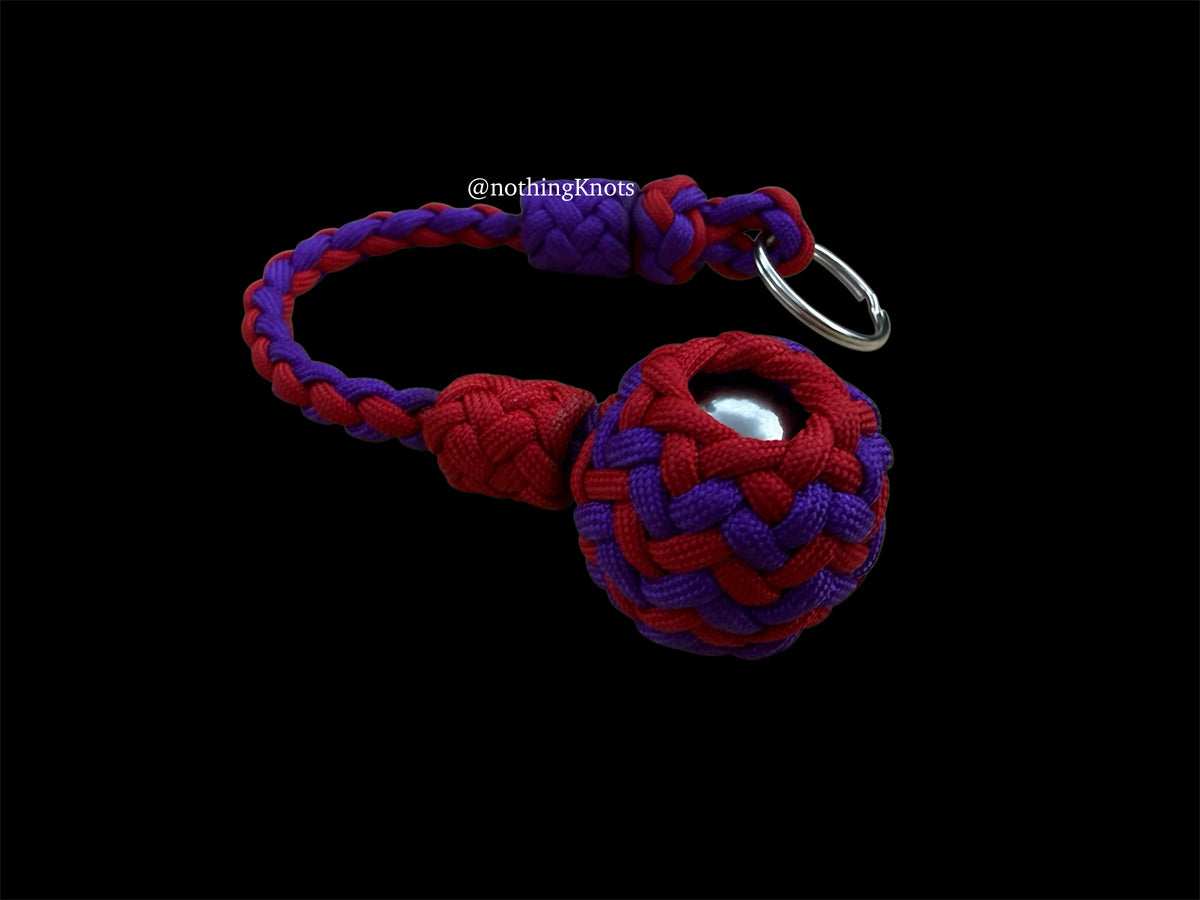 Decorative Paracord Wrapped 1.25 inch steel ball in Imperial Red and Acid Purple on a split ring